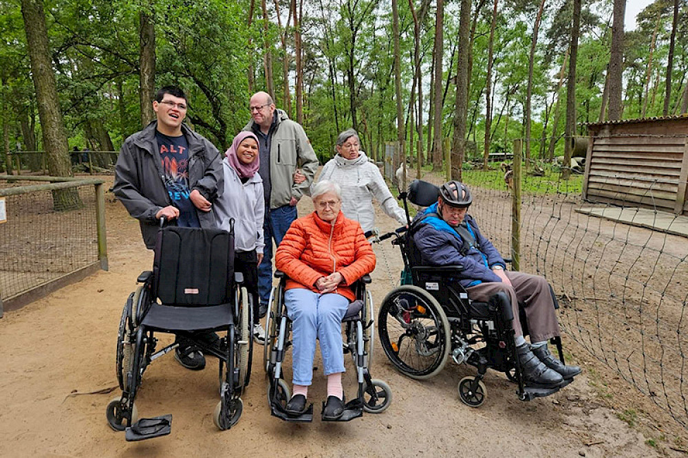 Bild zeigt Personen im Rollstuhl beim Ausflug in den Tierpark.